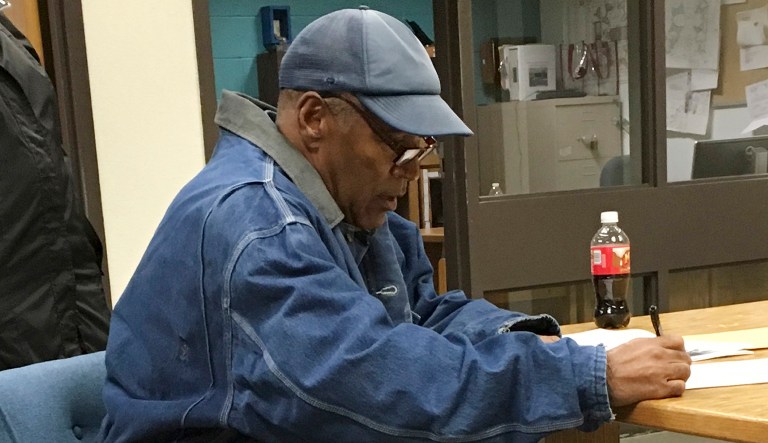 Former football legend O.J. Simpson signs documents at the Lovelock Correctional Center in Nevada. Simpson was released early Sunday after serving nine years for a botched hotel room heist. (Brooke Keast/Nevada Department of Corrections via AP)