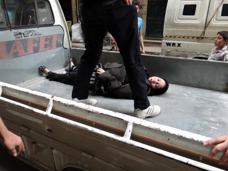 This citizen journalism image provided by Aleppo Revolution Against Assad's Regime, which has been authenticated based on its contents and other AP reporting, shows a Syrian man putting an injured woman into a car after being shot by a Syrian Army sniper, in the neighborhood of Bustan Al-Qasr in Aleppo, Syria, Thursday, April. 11, 2013. (AP Photo/Aleppo Revolution Against Assad's Regime)