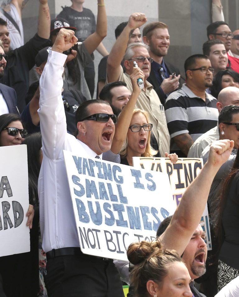 Jeff Hess, left, and his wife, Kari, second from left, co-owners of Nor Cal Vape, in Redding, Calif., celebrate with other Electronic Cigarette supporters after a bill to regulate E-Cigarettes as tobacco products stalled in an Assembly committee last year. (AP Photo/Rich Pedroncelli)