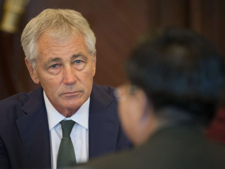 U.S. Defense Secretary Chuck Hagel, left, listens to Lt. Gen. Wang Guanzhong, right, China's deputy chief of General Staff, at the start of their meeting, Saturday, May 31, 2014 in Singapore. Hagel warned an international security conference Saturday that the U.S. 