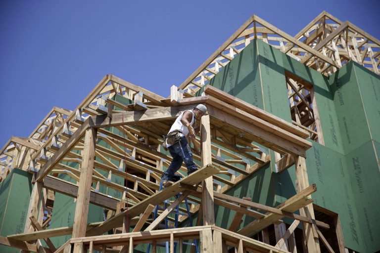 In this Wednesday, July 30, 2014 photograph, a builder works on the construction of new homes in Belmar, N.J. The Commerce Department reports on U.S. home construction in August on Thursday, Sept. 18, 2014. (AP Photo/Mel Evans)