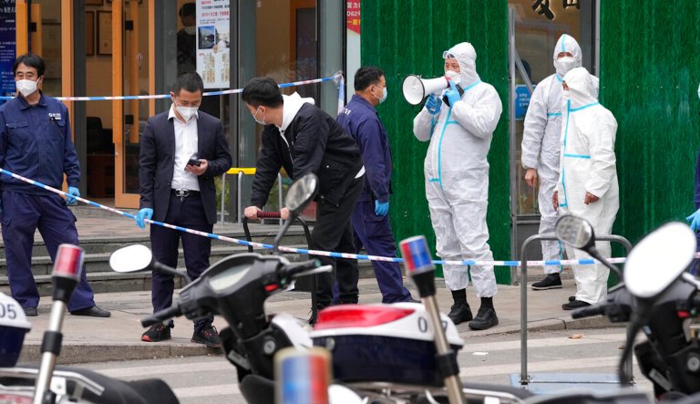 Workers wait to collect deliveries for a locked down community on Sunday, March 13, 2022, in Beijing. The number of new coronavirus cases in an outbreak in China's northeast tripled Sunday and authorities tightened control on access to Shanghai in the east, suspending bus service to the city of 24 million and requiring a virus test for anyone who wants to enter.