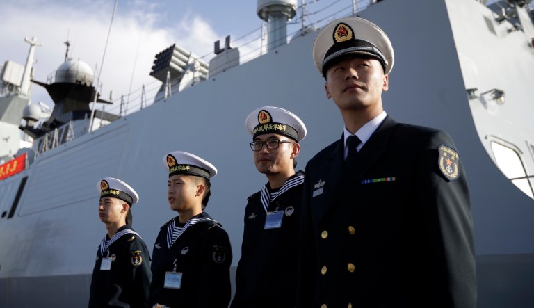 Chinese navy officials stand in front of the ship Daqing on Dec. 7, 2016, in San Diego.