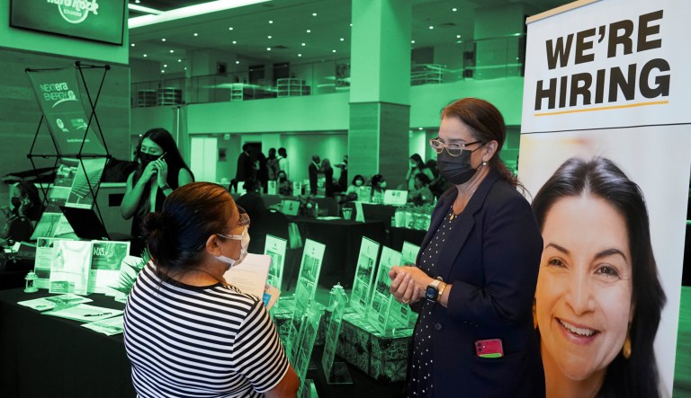Marriott human resources recruiter Mariela Cuevas, left, talks to Lisbet Oliveros, during a job fair at Hard Rock Stadium, Friday, Sept. 3, 2021, in Miami Gardens, Fla.