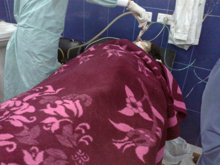 This April 13, 2013 citizen journalism image provided by Aleppo Media Center AMC which has been authenticated based on its contents and other AP reporting, shows a doctor treating a woman injured in what rebels claim was a chemical attack in Aleppo, Syria. Two Syrian officials denied Friday, April 26, 2013 that government forces had used chemical weapons against rebels, Damascus' first response to U.S. assertions that it had. On Thursday, the White House and other top Obama administration officials said that U.S. intelligence had concluded with 