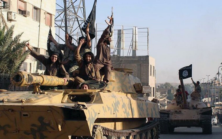 Al Qaeda linked Islamic State fighters ride tanks during a parade in Raqqa, Syria. (Raqqa Media Center via AP, File)