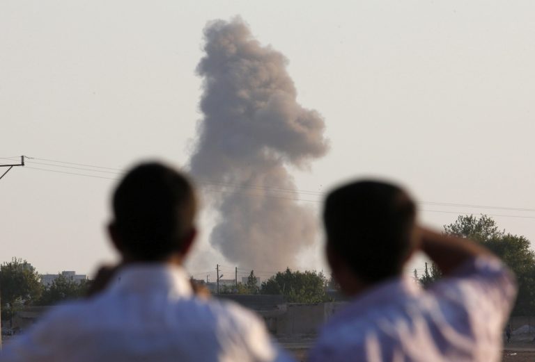 Turkish Kurds standing on the outskirts of Suruc, on the Turkey-Syria border, watch smoke rise following an airstrike in Kobani, Syria, where the fighting between militants of the Islamic State group and Kurdish forces intensified, Tuesday, Oct. 7, 2014. Kobani, also known as Ayn Arab and its surrounding areas have been under attack since mid-September, with militants capturing dozens of nearby Kurdish villages. (AP Photo/Lefteris Pitarakis)