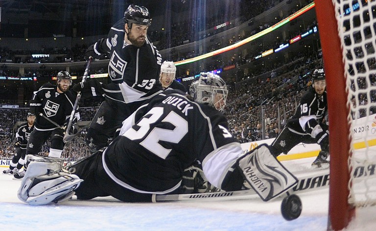   The puck shot for a goal by New Jersey Devils' Patrik Elias, of Czech Republic, not shown, passes Los Angeles Kings' goalie Jonathan Quick of Lithuania, in the third period during Game 4 of the NHL hockey Stanley Cup finals, Wednesday, June 6, 2012, in Los Angeles. Los Angeles Kings' Willie Mitchell watched the play. The Devils won the game 3-1. (AP Photo/Harry How, Pool)  
