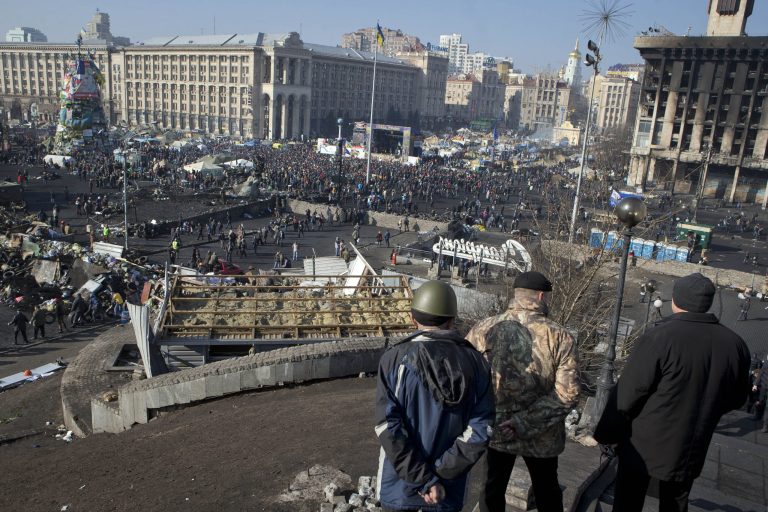 Anti-government protesters watch the crowd gathering in central Kiev, Ukraine, on Friday. (AP Photo/Darko Bandic)