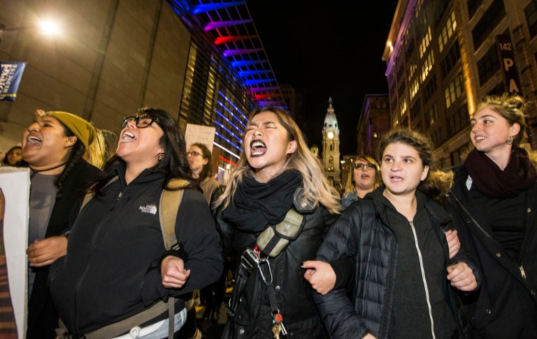 Protesters unhappy with the presidential election march north on Broad Street arm-in-arm Thursday in Philadelphia. (Charles Fox/The Philadelphia Inquirer via AP)