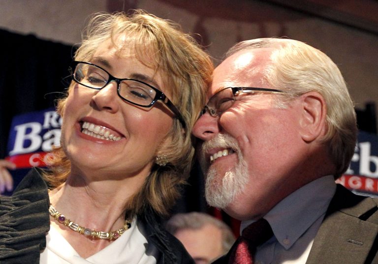   In an election to fill former Rep. Gabrielle Giffords, D-Ariz., congressional seat, Democratic candidate Ron Barber, right, celebrates a victory with Giffords, left, as he gives her a hug prior to speaking to supporters at a post election event, Tuesday, June 12, 2012, in Tucson, Ariz. Gabrielle Giffords' former district director, in a special election for the seat Giffords left in January to focus on her recovery from a gunshot wound to her head during a gunman's shooting spree a year earlier.(AP Photo/Ross D. Franklin, pool)  
