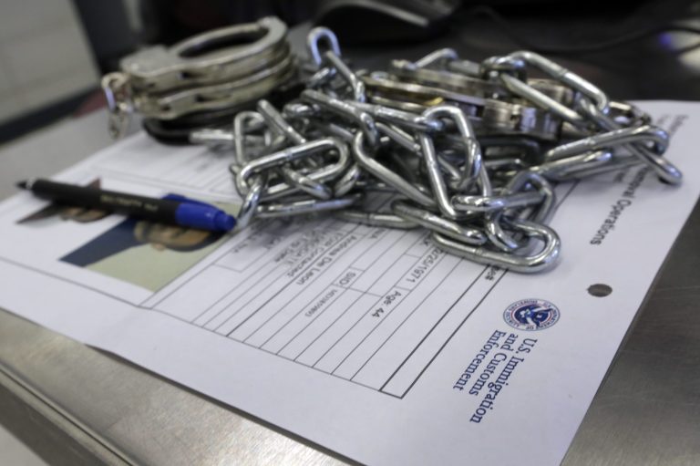 In this March 3, 2015 photo, handcuffs and chains sit on the paperwork of a person arrested by Immigration and Customs Enforcement officers after a series of early-morning arrests in New York. Immigrant and Customs Enforcement say an increasing number of cities and counties across the United States are limiting cooperation with the agency and putting its officers in dangerous situations as they track down foreign-born criminals. (AP Photo/Richard Drew)