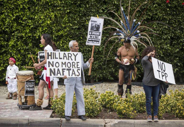 Los Angeles community members wait for Hillary Rodham Clinton's motorcade as they oppose the Trans-Pacific Partnership (TPP) and Trade Promotion Authority (TPA) known as 