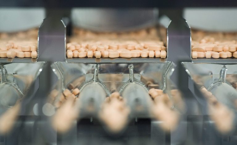 FILE- In this Thursday, July 12, 2012, file photo, Centrum multivitamins are shown on the packaging line at the Pfizer plant in Montreal. The Justice Department said Wednesday, Dec. 12, 2012, that Pfizer Inc. will pay $55 million to resolve allegations that Wyeth LLC promoted the drug Protonix for uses that were not approved by the Food and Drug Administration. Pfizer acquired Wyeth in October 2009.