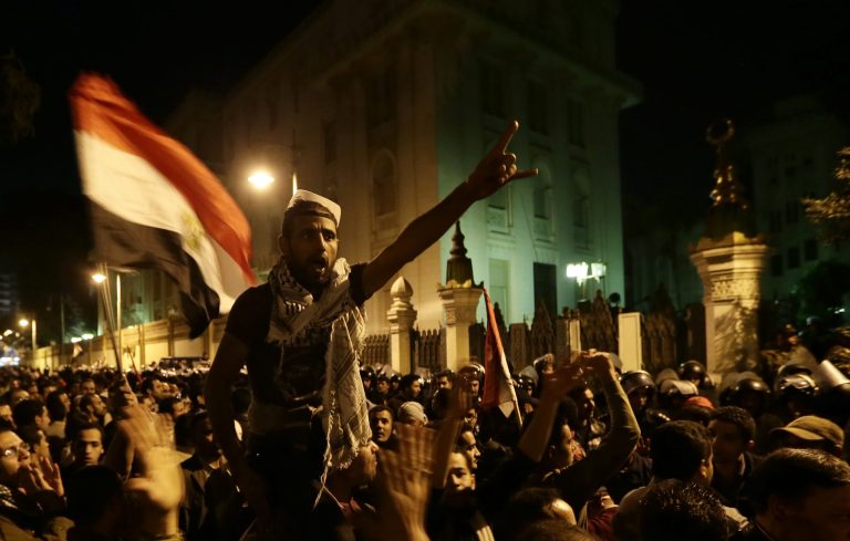   Egyptian protesters chant anti Muslim Brotherhood and Egyptian President Mohammed Mosri slogans outside the presidential palace after they broke a barbed wire barricade keeping them from getting closer to the presidential palace, in Cairo, Egypt, Friday, Dec. 7, 2012. Egypt's political crisis spiraled deeper into bitterness and recrimination Friday as thousands of Islamist backers of the president vowed vengeance at a funeral for men killed in bloody clashes earlier this week and large crowds of the president's opponents marched on his palace to increase pressure after he rejected their demands. (AP Photo/Hassan Ammar)  