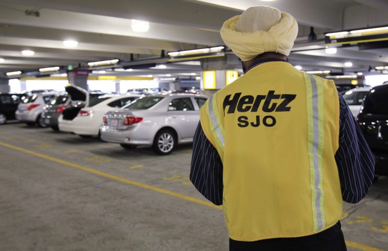 FILE - In this May 9, 2011 file photo, a Hertz rental car worker checks out cars at San Jose International Airport in San Jose, Calif. Hertz on Tuesday, March 18, 2014 said it plans to spin off its equipment rental business into a separate publicly traded company. (AP Photo/Paul Sakuma, File)
