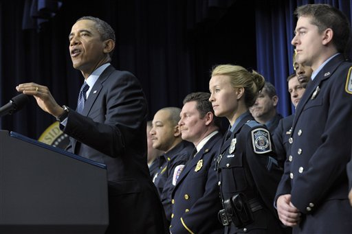 President Barack Obama, accompanied by first responders behind him, gestures as he speaks in the South Court Auditorium of the Eisenhower Executive Office building on the White House complex in Washington, Tuesday, Feb. 19, 2013, to urge Congress to come up with an alternative plan to avert automatic spending cuts set to kick in on March 1, 2013. (AP Photo/Susan Walsh)