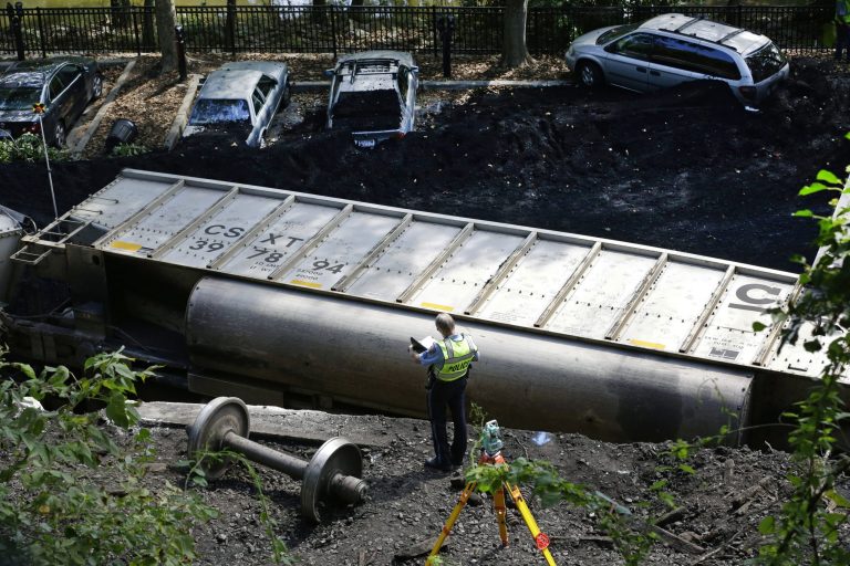 An official inspects part of a CSX freight train that derailed alongside a parking lot in Ellicott City.  (AP Photo)