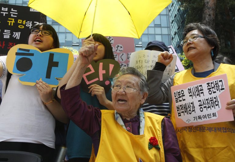 FILE - In this Wednesday, May 15, 2013 file photo, former South Korean comfort woman Kil Un-ock, center, who was forced to serve for the Japanese troops as a sexual slave during World War II, shouts slogans during a rally against the recent comment of Osaka Mayor Toru Hashimoto in front of Japanese Embassy in Seoul, South Korea.  Japan's top government spokesman said Thursday that Tokyo would consider re-examining a 20-year-old study that led to a landmark apology over its forced prostitution in World War II. (AP Photo/Ahn Young-joon, File)
