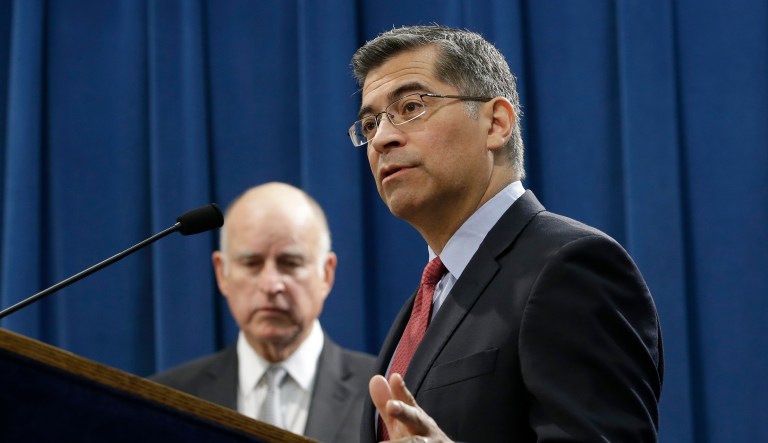 In documents filed Friday to Judge John Mendez of the U.S. District Court for the Eastern District of California, state Attorney General Xavier Becerra (pictured center, speaking) said his office intends to request the case be transferred from Sacramento to San Francisco next week. (AP Photo/Rich Pedroncelli)