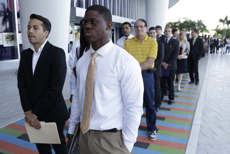 FILE - In this Wednesday, Oct. 23, 2013, file photo, Luis Mendez, 23, left, a student at Miami Dade College, left, and Maurice Mike, 23, right, a student at Florida International University,  wait in line at an internship job fair held by the Miami Marlins, at Marlins Park in Miami. Payroll processor ADP issues its report on job growth for the month on Wednesday, Oct. 30, 2013. (AP Photo/Lynne Sladky, File)
