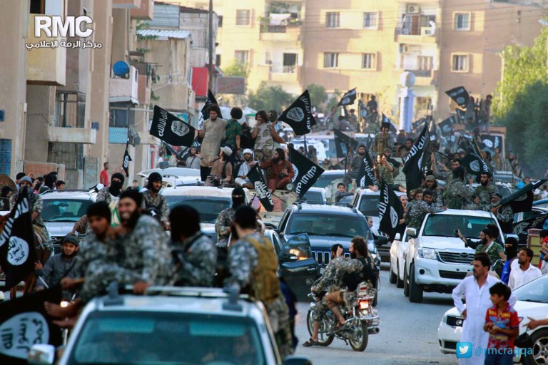 In this undated file image posted on Monday, June 30, 2014, by the Raqqa Media Center of the Islamic State group, a Syrian opposition group, which has been verified and is consistent with other AP reporting, fighters from the Islamic State group parade in Raqqa, north Syria. (AP Photo/Raqqa Media Center of the Islamic State group, File)