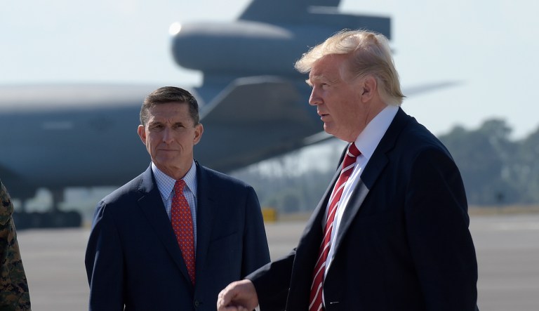 President Donald Trump passes  Joint Chiefs Chairman Gen. Joseph Dunford, left, and National Security Adviser Michael Flynn as he arrives via Air Force One at MacDill Air Force Base in Tampa, Fla., Monday, Feb. 6, 2017. Trump stopped for a visit to the headquarters for U.S. Central Command and U.S. Special Operations Command before returning to Washington.