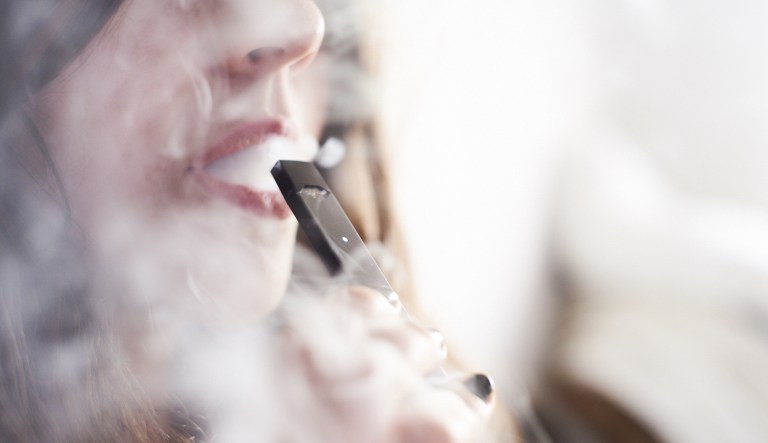 A person smokes a Juul Labs Inc. e-cigarette in the Brooklyn Borough of New York, on Sunday July 8, 2018. 