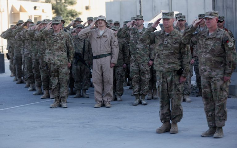 U.S. service members salute during a ceremony on the thirteenth anniversary of the 9/11 terrorist attacks in front of the World Trade Center Memorial at Bagram Airfield, Afghanistan Thursday, Sept. 11, 2014. (AP Photo/Massoud Hossaini)
