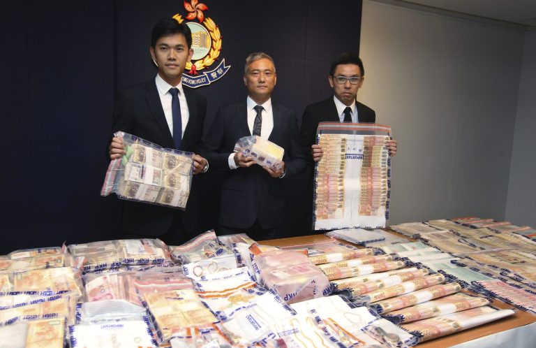 In this photo June 9, 2014 shows the officers from Hong Kong Policeâs organized crime and triad bureau display stacks of cash seized after they launched an operation with counterparts in mainland China to smash a cross-border illegal gambling syndicate days before the start of the World Cup finals in Brazil. While teams battle for glory at footballâs biggest event, the biggest winners may be Asiaâs illegal bookmakers, who are thriving because demand from sports fans to place bets is surging but legal options are few. Government monopoly operators offer legal sports betting in a handful of Asian jurisdictions but there are thousands more black market operators. Asia accounts for just over half of the nearly $700 billion in illegal bets placed worldwide each year, according to a sports monitoring group. 
(AP Photo/Str)