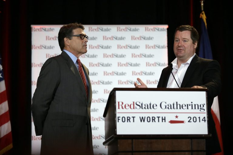 Governor Rick Perry watches as Erick Erickson makes comments about the governor to attendees at the 2014 Red State Gathering, Friday, Aug. 8, 2014, in Fort Worth, Texas. (AP Photo/Tony Gutierrez)