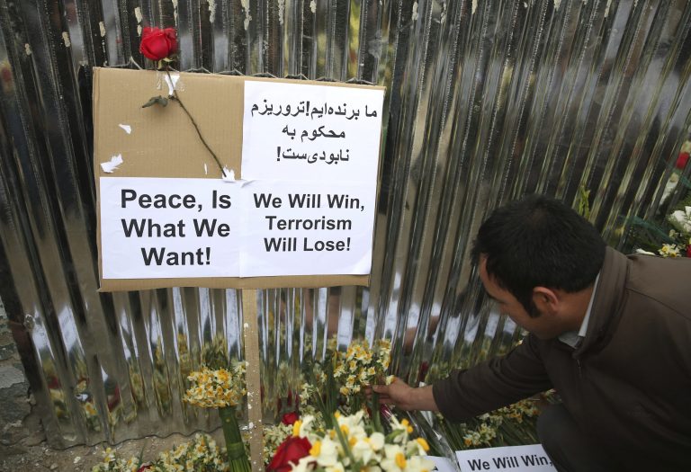 An Afghan puts flowers outside of the La Taverna du Liban restaurant, during an anti terrorism demonstration in Kabul on Sunday, Jan. 19. (AP Photo/Massoud Hossaini)