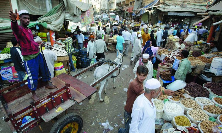 ADVANCE FOR USE MONDAY, DEC. 10, 2012 AND THEREAFTER - In this Thursday, Dec. 6, 2012 photo, people from different ethnic groups walk thorugh a market in Karachi, Pakistan. Since 1947, the city's population has grown from 435,000 to 18 million. (AP Photo/Fareed Khan)