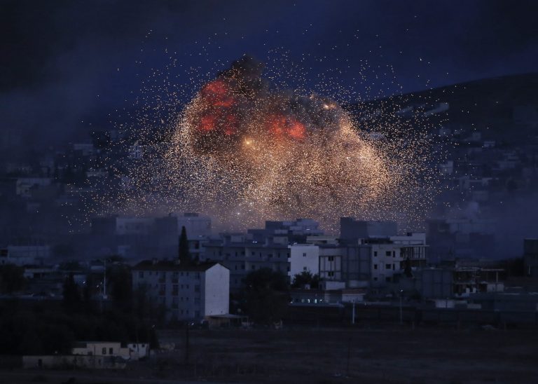 In this Oct. 20, 2014, file photo, thick smoke and flames from an airstrike by the U.S.-led coalition rise in Kobani, Syria, as seen from a hilltop on the outskirts of Suruc, at the Turkey-Syria border. (AP Photo/Lefteris Pitarakis, File)
