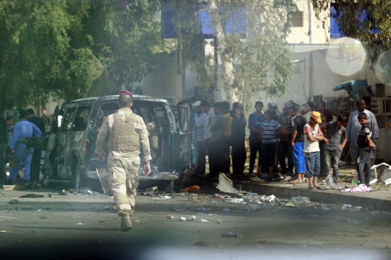   Iraqi security forces and civilians inspect the scene of a car bomb attack in the Kazimiyah area of Baghdad, Iraq, Saturday, June 16, 2012. Car bombs targeting religious processions in Iraq's capital killed and wounded scores of people on the last day of a Shiite pilgrimage already hit three times in some of the deadliest violence since American troops withdrew, police said. (AP Photo/Hadi Mizban)  