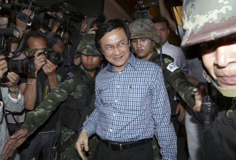 Former Thai Education Minister Chaturon Chaisang, center, walks after being detained by soldiers after a news conference at the Foreign Correspondents' Club of Thailand in Bangkok, Thailand Tuesday, May 27, 2014. Thai troops detained the Cabinet minister who defiantly emerged from hiding on Tuesday to condemn last week's military coup and urge a return to civilian rule, in the first public appearance by any member of the ousted government. (AP Photo/Apichart Weerawong)