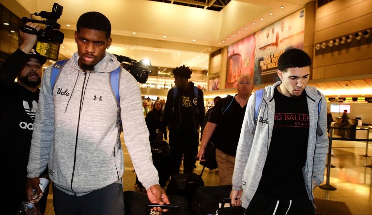 UCLA basketball players Cody Riley, left, LiAngelo Ball, right, and Jalen Hill, background center, are surrounded by the media as they leave the Los Angeles International Airport on Tuesday, Nov. 14, 2017, in Los Angeles. The three UCLA basketball players detained in China on suspicion of shoplifting returned home, where they may be disciplined by the school as a result of the international scandal. (AP Photo/Jae C. Hong)