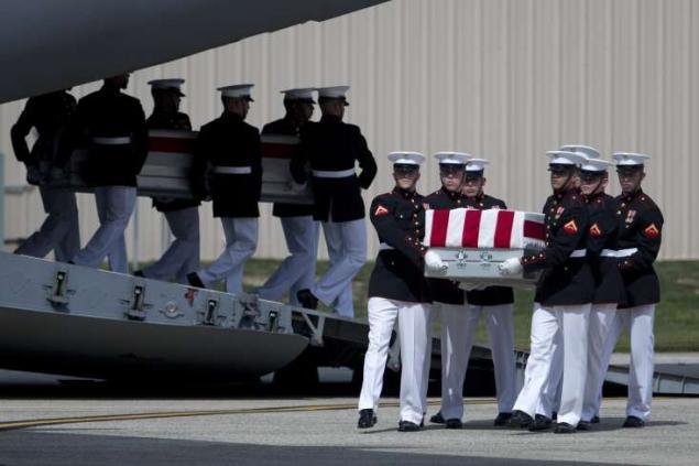 The flag-draped transfer cases of the bodies of Ambassador Chris Stevens, Tyrone Woods, Sean Smith and Glen Doherty, who died in Benghazi, Libya, are carried from their transport plane. AP Photo