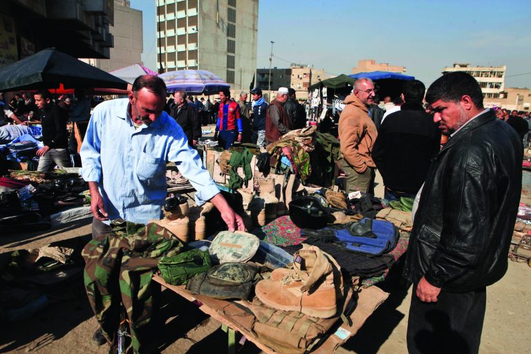 Street vendors sell used US army military gear in Baghdad, Iraq, Monday, Dec. 17, 2012. A year after the last American troops rumbled out of Iraq, the two countries are still trying to get comfortable with a looser, more nuanced relationship as the young democracy struggles to cope with ongoing political upheaval and the legacy of war. (AP Photo/ Karim Kadim)