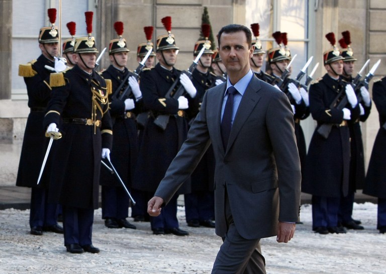 Syria President Bashar al-Assad walks past an honor guard as he arrives at the Elysee Palace for a meeting with French President Nicolas Sarkozy in Paris, Thursday Dec. 9, 2010. 