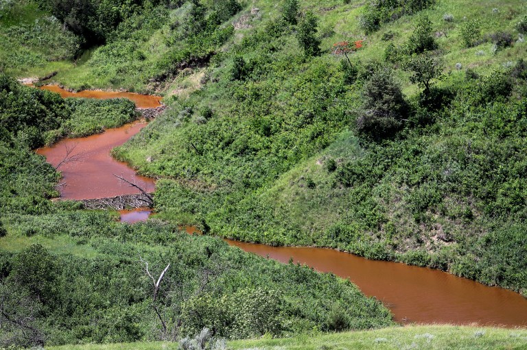 Saltwater leaks into this stream after running downhill, Thursday, July 10, 2014, near Mandaree, N.D. A pipeline leak on Fort Berthold Indian Reservation spilled 1 million gallons of saltwater, a byproduct of oil and gas production. Company officials say the leak likely started over the Fourth of July weekend. (AP Photo/Tyler Bell)
