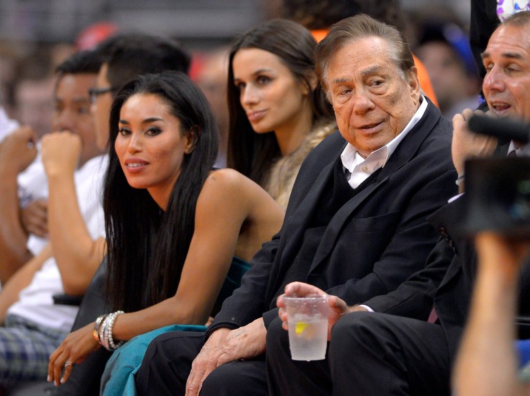 Los Angeles Clippers owner Donald Sterling, right, and V. Stiviano, left, watch the Clippers play the Sacramento Kings during the first half of an NBA basketball game in Los Angeles. (AP/Mark J. Terrill)