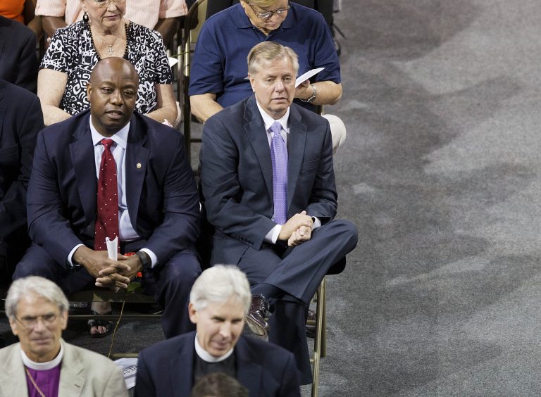 Republican presidential candidate Sen. Lindsey Graham, R-S.C., right, and Sen. Tim Scott, R-S.C., left, attend a memorial service for the victims of the shooting at Emanuel AME Church, Friday, June 19, 2015, in Charleston, S.C. (AP Photo/David Goldman)