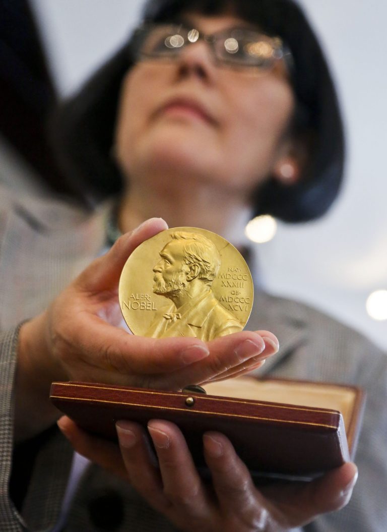 Sandra Palomino, director of historical manuscripts at Heritage Auctions, holds the1962 Nobel Prize for Physiology or Medicine awarded to Dr. Francis Harry Compton Crick, Wednesday, April 10, 2013 in New York. On Thursday, the molecular biologist's medal and accompanying diploma will be sold by Heritage Auctions, which estimates it could fetch at least $500,000. (AP Photo/Bebeto Matthews)