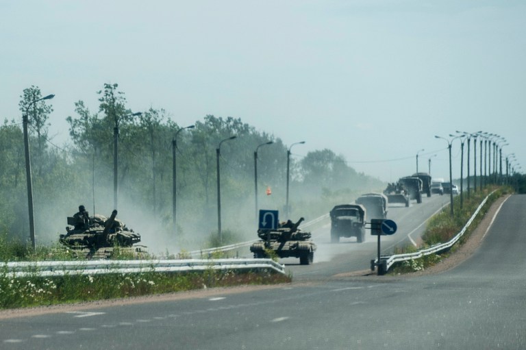Pro-russian troops in tanks, several armored vehicles, and tracks drive on a road in the direction of Donetsk not far from Debaltseve, Donetsk region, eastern Ukraine, Friday, June 20, 2014. (AP Photo/Evgeniy Maloletka)