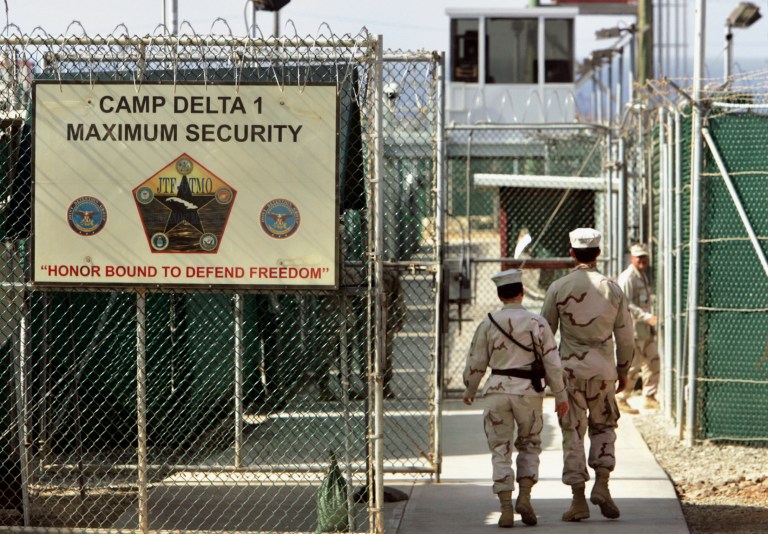 FILE - In this June 27, 2006 file photo, reviewed by a U.S. Department of Defense official, U.S. military guards walk within Camp Delta military-run prison, at the Guantanamo Bay U.S. Naval Base, Cuba. President Barack Obama is pushing to overcome obstacles to closing the Guantanamo Bay prison, an elusive goal which has frustrated him since he took office. That is setting the White House on a collision course with Congress in its bid to loosen restrictions for moving out detainees.  (AP Photo/Brennan Linsley, File)