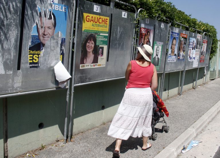   A woman looks at posters for the French general election, in Nice, southeastern France, Saturday, June 9, 2012, on the eve of the first round of the French general election. The second round will take place on June 17t to elect the 14th National Assembly of the 5th Republic. (AP Photo/Lionel Cironneau)  