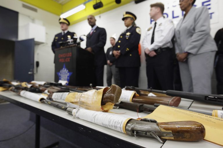 Chicago Police First Deputy Superintendent Alfonsa Wysinger, second from left, speaks at a news conference in Chicago in summer 2013 with a display of recently seized guns, part of the 574 that had been seized in the city since Jan. 1. (AP Photo/M. Spencer Green, File)