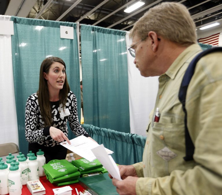 In this April 22, 2014 photo, Erin Wilson, of Hannaford Bros. supermarket company, left, talks with a job seeker during a job fair Columbia-Greene Community College in Hudson, N.Y. The Labor Department releases weekly jobless claims on Thursday, April 24, 2014. (AP Photo/Mike Groll)
