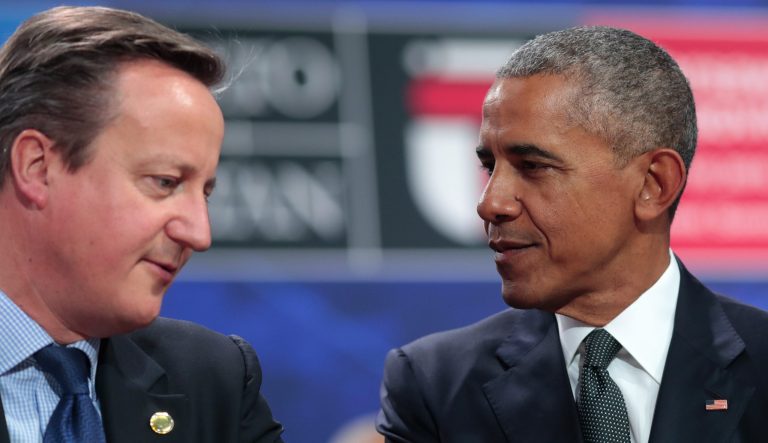 Barack Obama listens to British Prime Minister David Cameron.